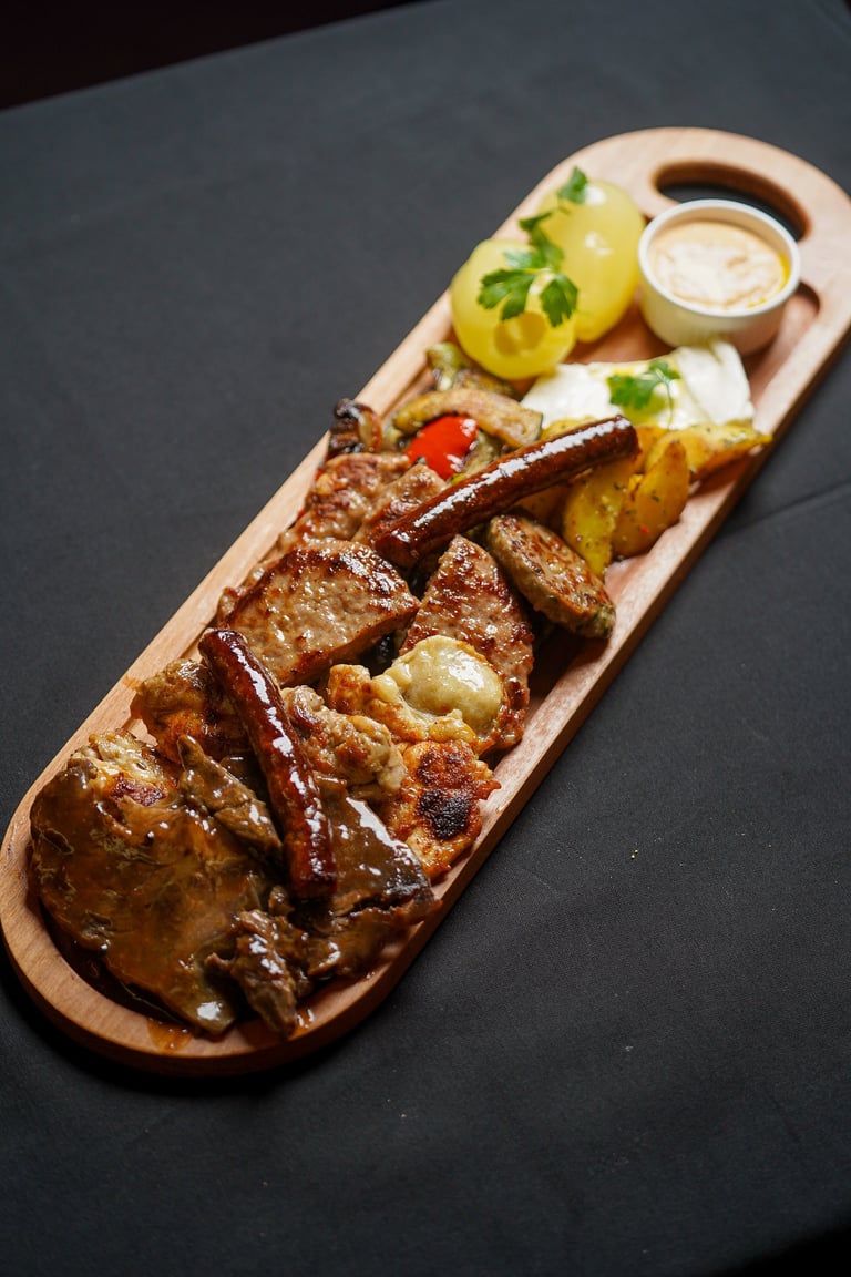Grilled meat and sausage platter on wooden board